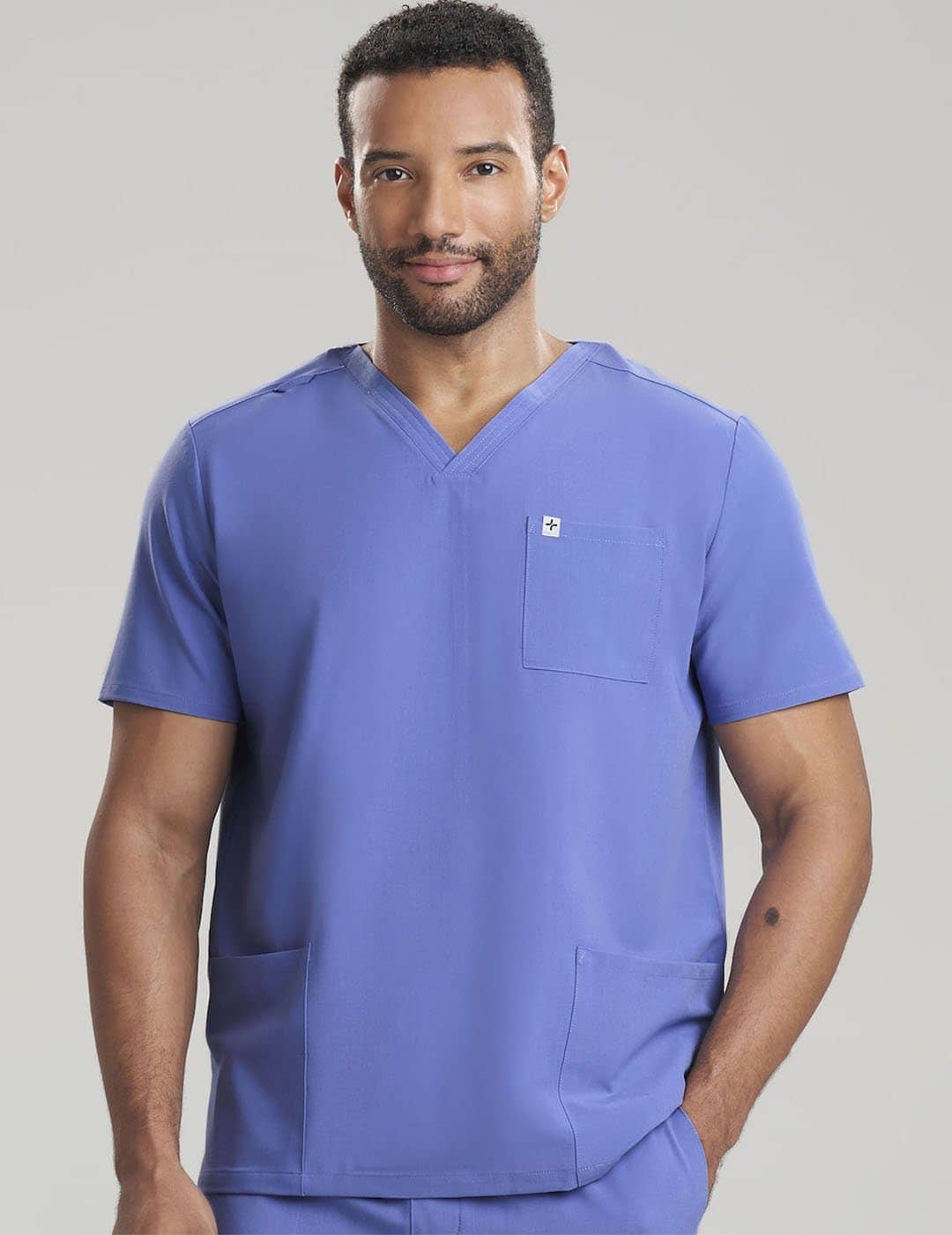 Premium Ceil Men&#39;s 3-Pocket V-Neck Scrub Top in limited edition style by Care+Wear, offering exclusivity and functionality. Model is wearing size Large