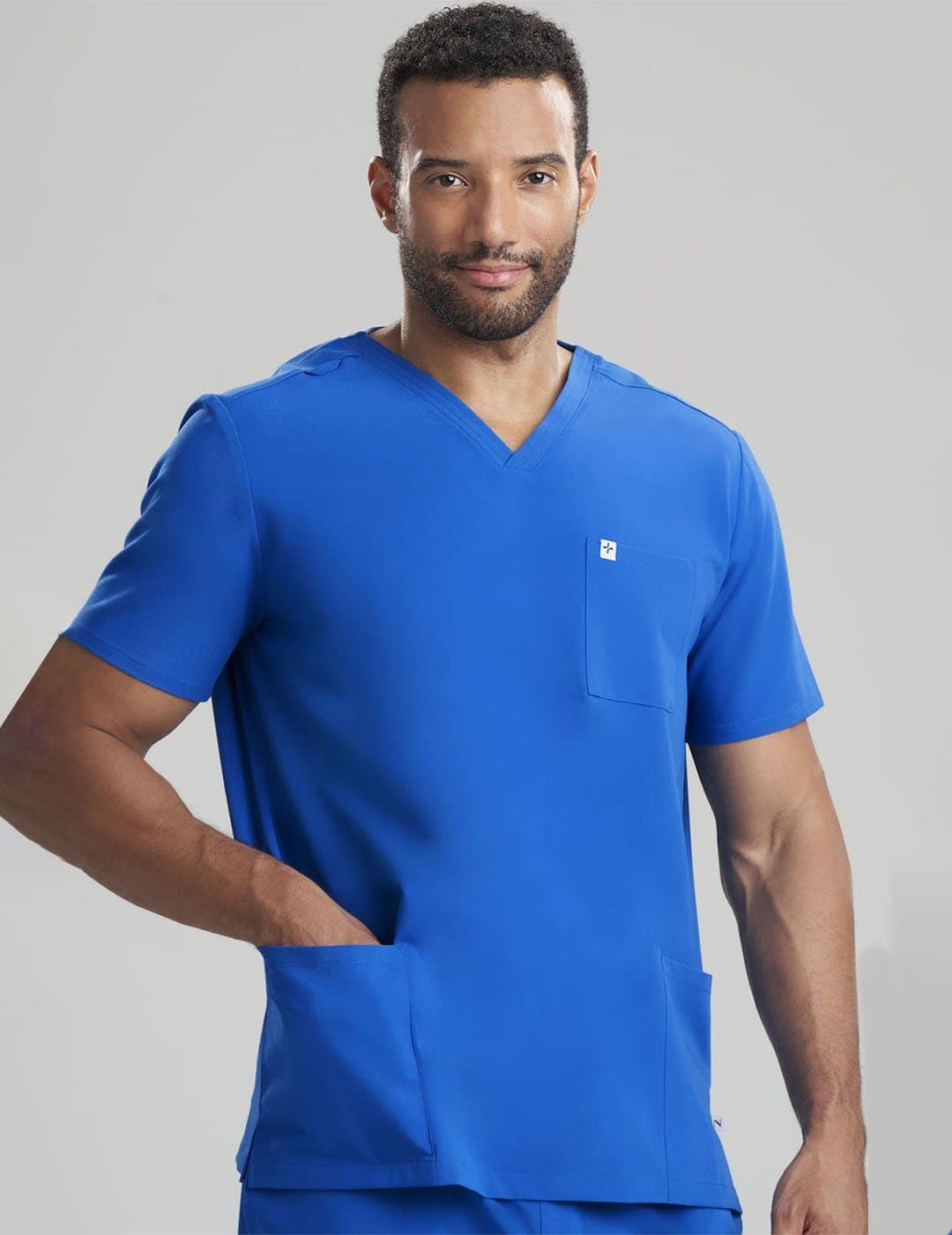 Limited Edition Ceil Men&#39;s 3-Pocket V-Neck Scrub Top by Care+Wear, combining a unique color with practical design for medical professionals. Model is wearing size Large